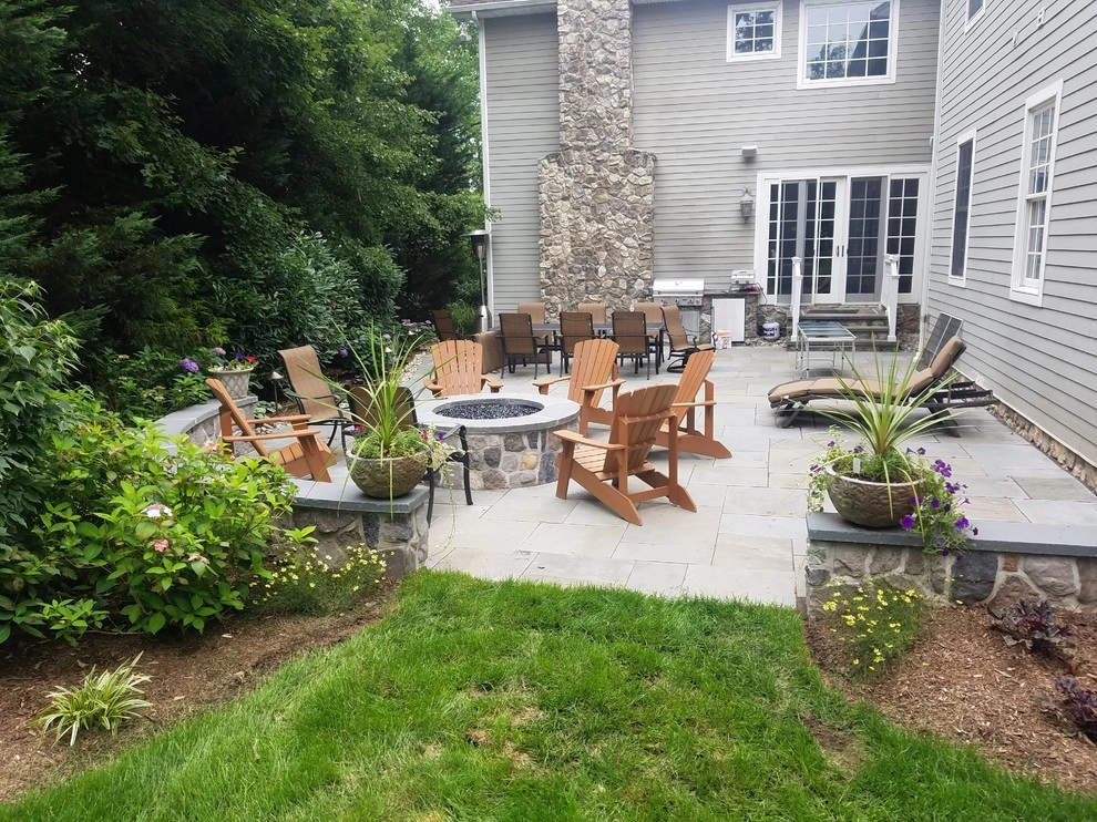 Patio with stone wall and fire pit by Z.O. Landscaping - Photo 9