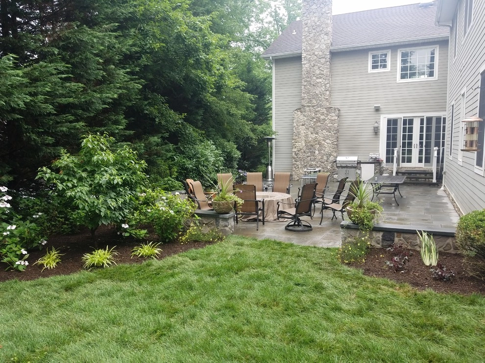 Patio with stone wall and fire pit by Z.O. Landscaping - Photo 8