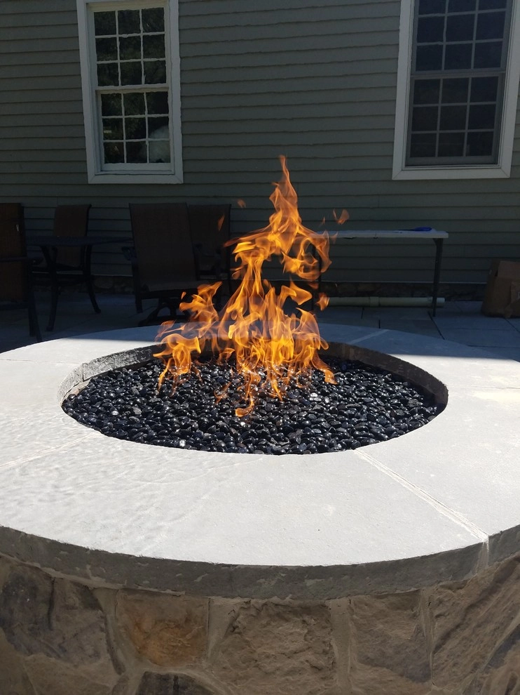 Patio with stone wall and fire pit by Z.O. Landscaping - Photo 2
