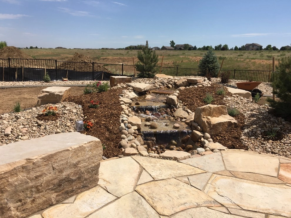 Flagstone Patio, Seat Boulders, Water Feature and Fire Pit; Windsor, CO 2016 by Colorado Vista Landscape Design, Inc. - Photo 2