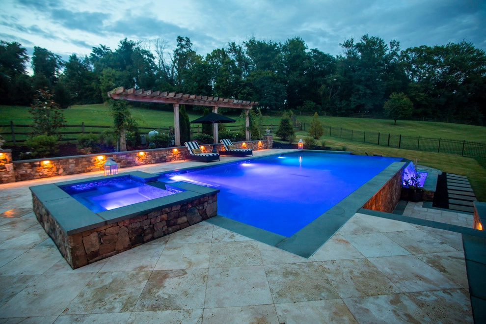 Infinity edge swimming pool, fireplace and travertine patio. by Rock Water Farm - Photo 6
