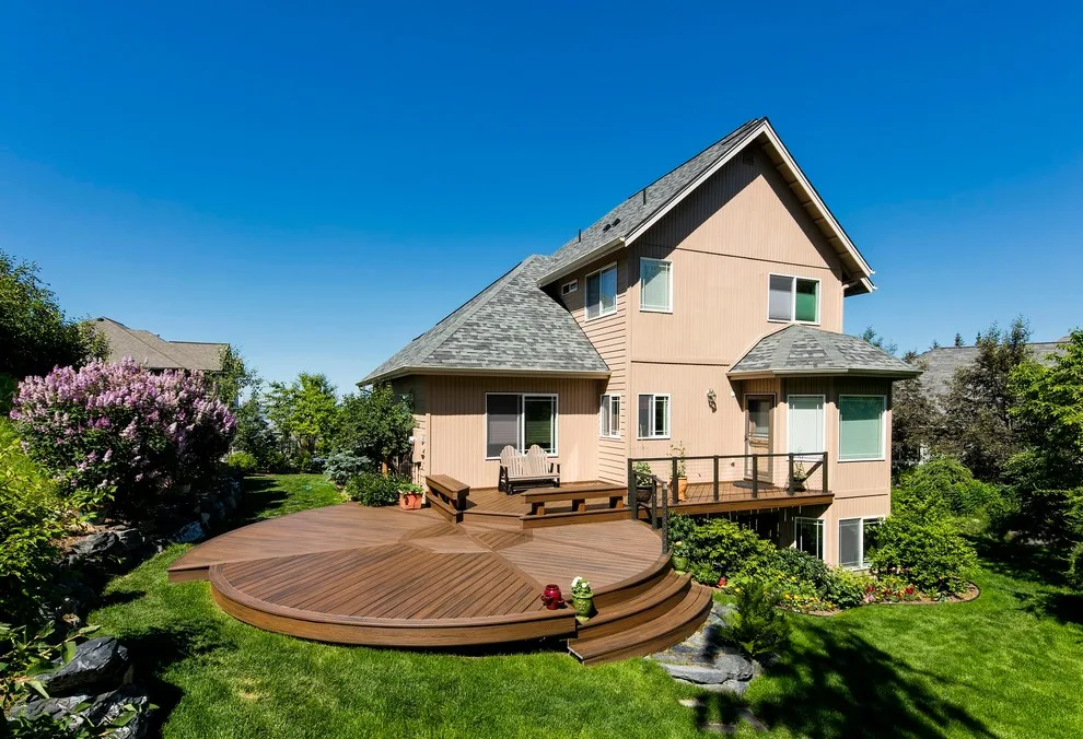 Circular Trex deck with inlay, integrated benches, and aluminum-framed cable railing by Treeline Construction - Photo 3
