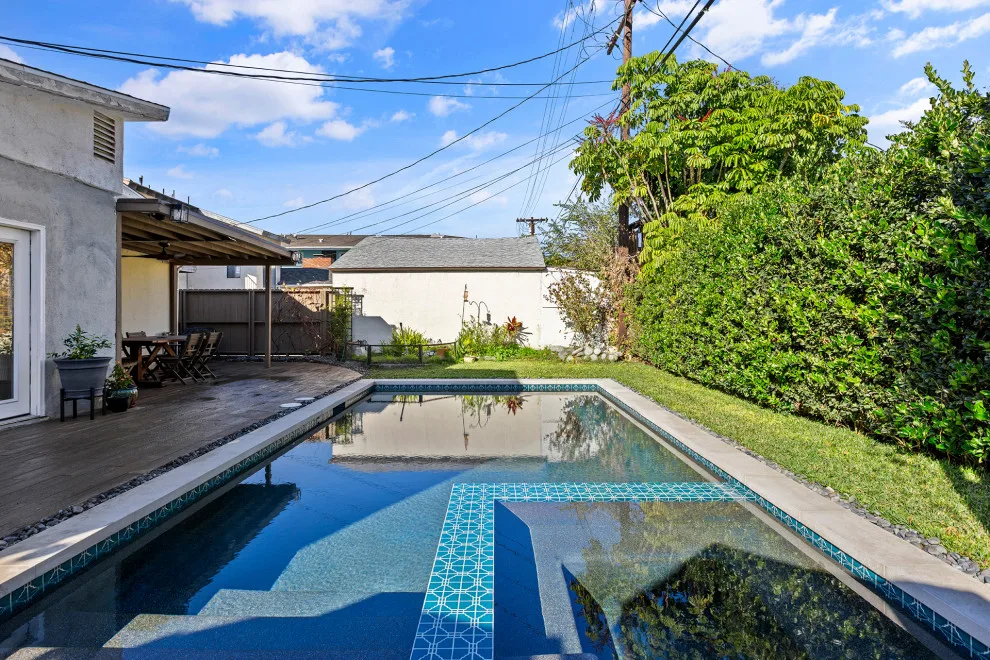 Contemporary black pebble pool and spa for a compact backyard by Vision Home Remodeling, Inc. - Photo 3