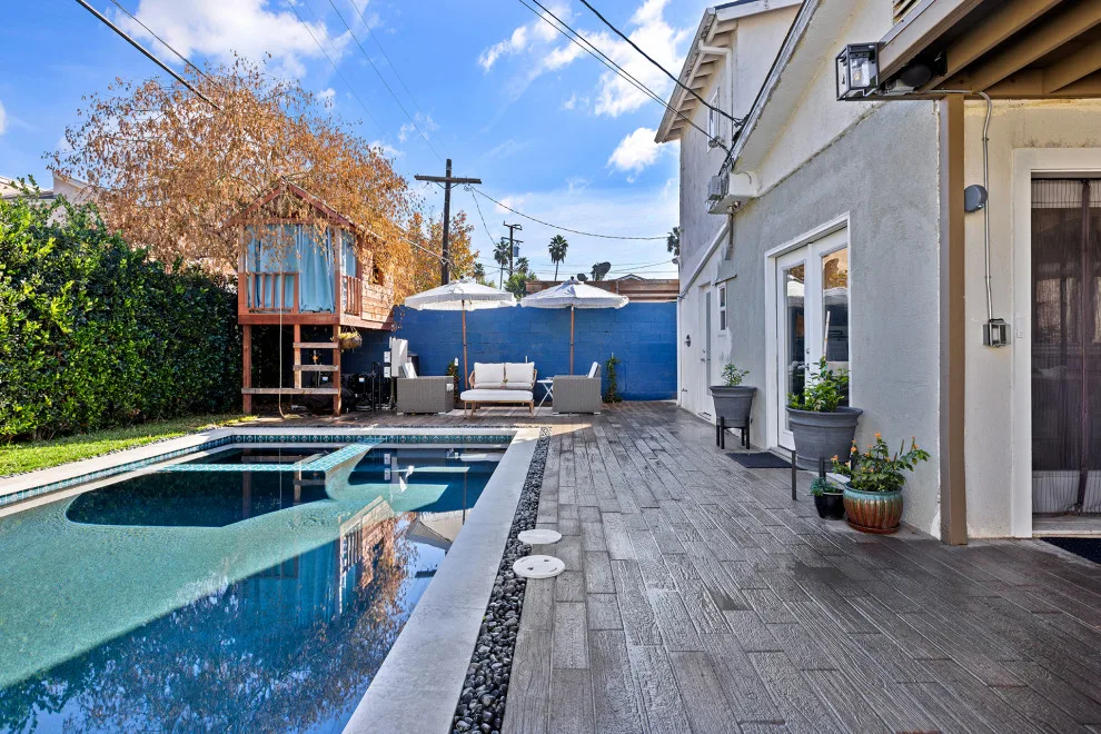 Contemporary black pebble pool and spa for a compact backyard by Vision Home Remodeling, Inc. - Photo 2
