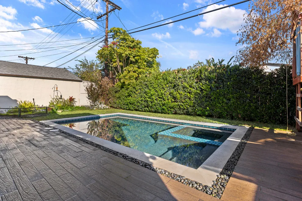 Contemporary black pebble pool and spa for a compact backyard by Vision Home Remodeling, Inc. - Photo 4