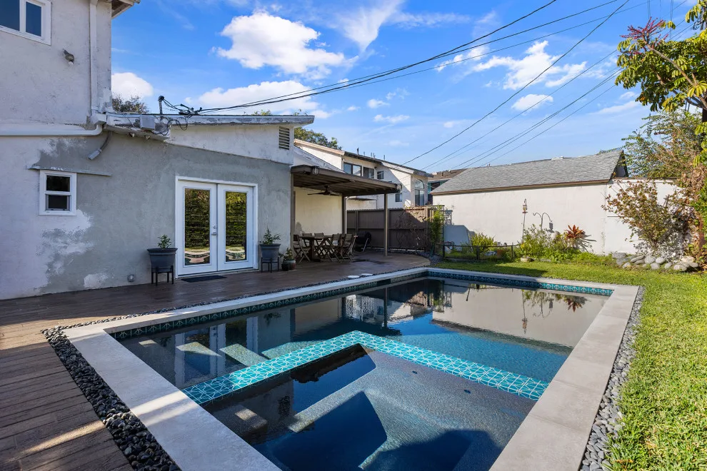 Contemporary black pebble pool and spa for a compact backyard by Vision Home Remodeling, Inc. - Photo 8