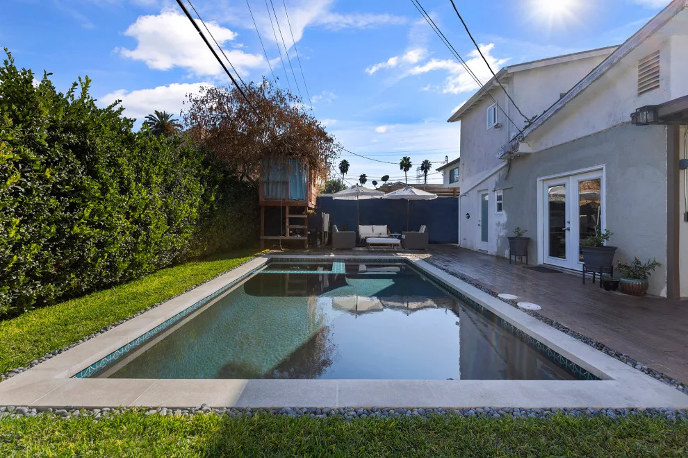 Contemporary black pebble pool and spa for a compact backyard by Vision Home Remodeling, Inc. - Photo 9
