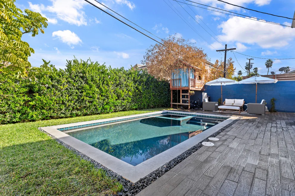 Contemporary black pebble pool and spa for a compact backyard by Vision Home Remodeling, Inc. - Photo 7