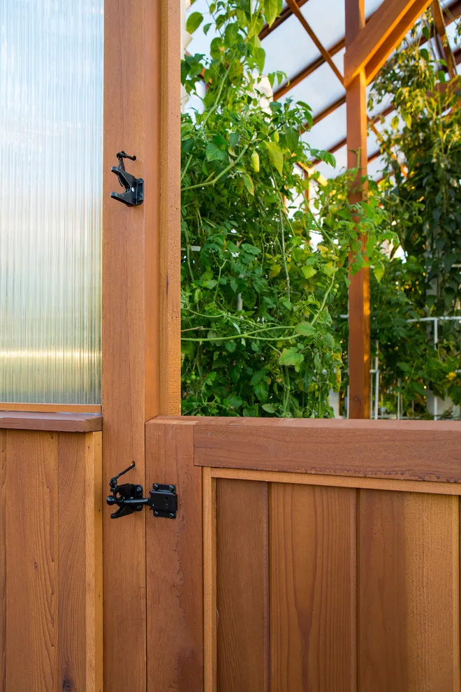 Modern deck featuring custom railings, flooring, gate, and greenhouse by Treeline Construction - Photo 7