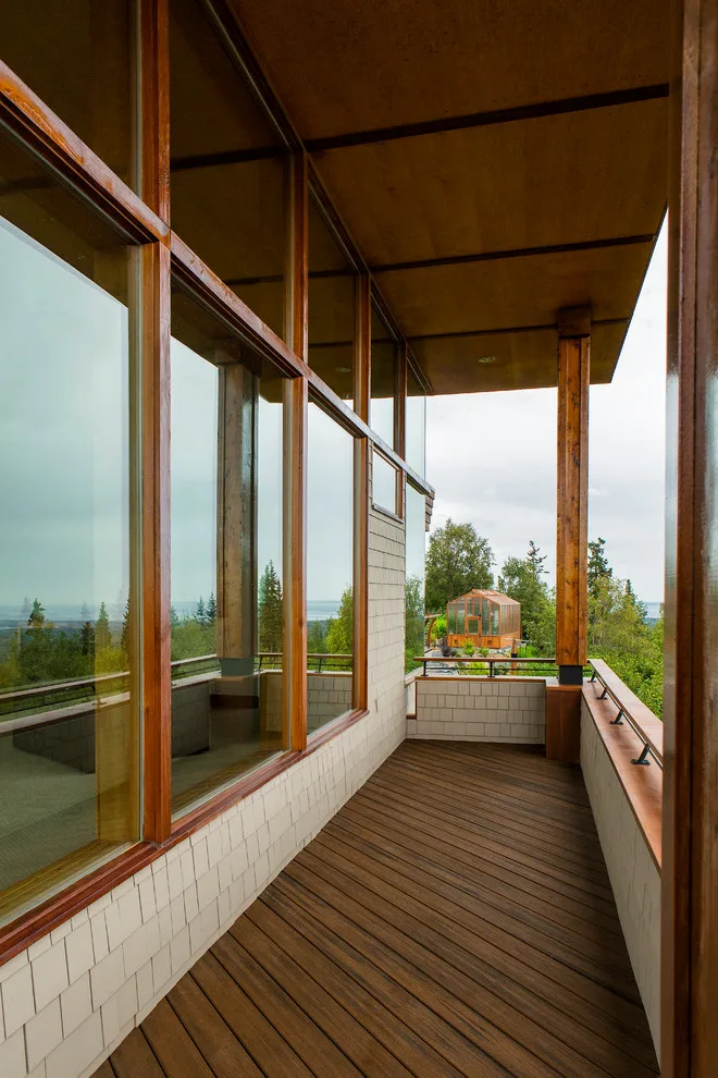 Modern deck featuring custom railings, flooring, gate, and greenhouse by Treeline Construction - Photo 11