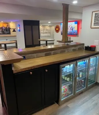 Basement Renovation featuring a bar and game area by Casino Co. Renovations