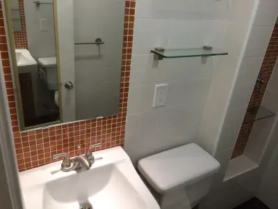 Modern Bathroom with Rust Tiles by Cambridge Home Renovations