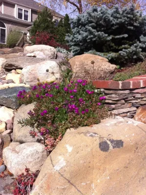 Bluestone and Brick Paving with Boulder Walls by Hively Landscaping Inc.