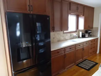 Wooden Kitchen with Light-Colored Counters by July's Quality Construction & Remodeling