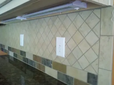 Ivory Kitchen Backsplash with Tumbled Stone by Floor Pro South, LLC