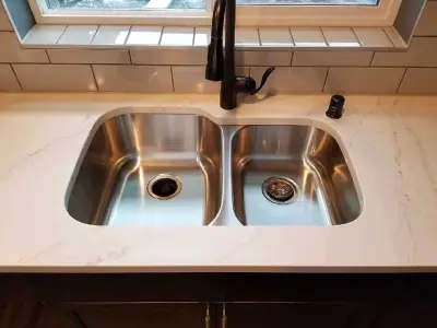 Calcatta Gold Countertops with Black Cabinets by Spokane Stone Creations LLC