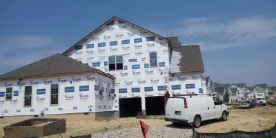 Two new homes: one being painted and one having a roof installed — Home Renovation & Remodeling Services project by Nc Woodmasters