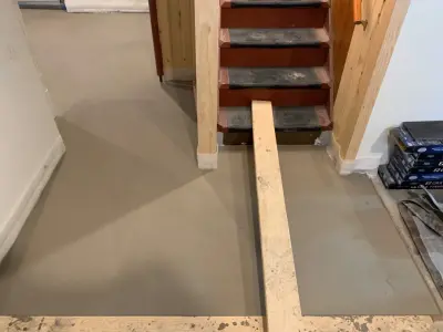 Basement leveling and flooring installation (Before and After) by Ultimate Remodeling