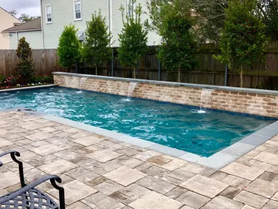 L-Shaped Pool with Stone Deck — Landscape Design project by Artscape Land Design in New Orleans