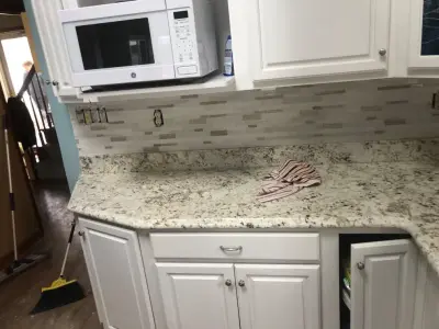 Installation of kitchen backsplash tiles — Home Renovation & Remodeling Services project by Uptown Construction