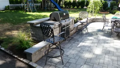 Maplewood expanded side patio with water feature by Z.O. Landscaping