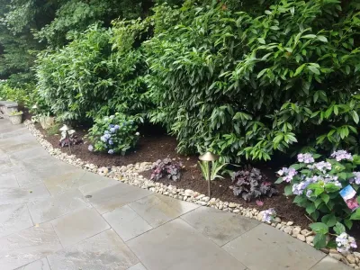 Patio with stone wall and fire pit — Landscape Design project by Z.O. Landscaping