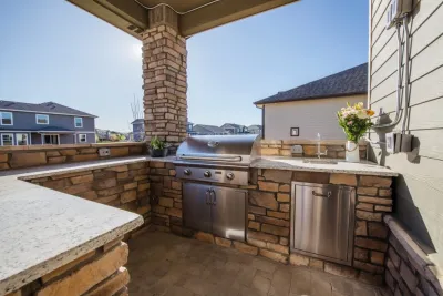 Stone Fireplace Wall and Outdoor Kitchen — Landscape Construction project by All Terrain Landscaping