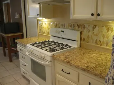 Rhomboid Onyx Backsplash with Juparana Granite Countertop — Kitchen Remodeling project by Bella Stone Countertops