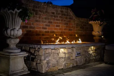 outdoor area with firepit, water feature and hot tub by Ayers Hardscapes & Landscapes LLC