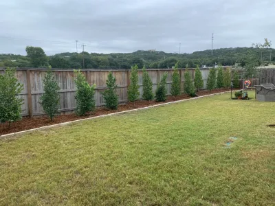 Cherry Laurel, cedar mulch, weed barrier fabric, chop stone border install — Landscape Construction project by Boerjan's Landscaping & Design