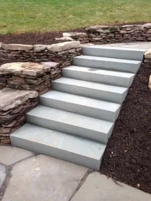 Backyard Patio and Natural stone retaining walls with stairs by Classic Stonescaping & Gardens