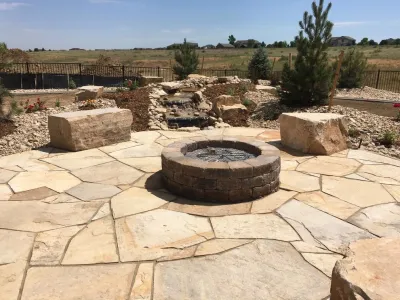 Flagstone Patio, Seat Boulders, Water Feature and Fire Pit; Windsor, CO 2016 — Landscape Construction project by Colorado Vista Landscape Design, Inc. in Windsor