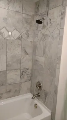 Personalized Gray Tile Shower — Kitchen Remodeling project by July's Quality Construction & Remodeling