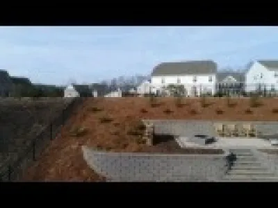 Sloped yard retaining walls with patio / firepit by H2O-Matic Outdoor Creations