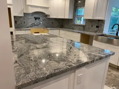 Kitchen featuring a complete backsplash in Viscount white granite by Stones & Designers