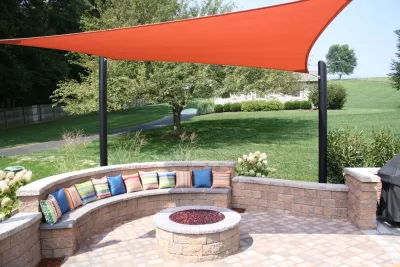 Sail shade over a paver patio and a gas firepit — Landscape Construction project by New Castle Lawn & Landscape