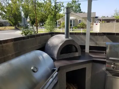 Alfresco Cooking Area Featuring Charcoal Grill, Brick Pizza Oven, and Gas BBQ by L.A. Custom Grill Islands