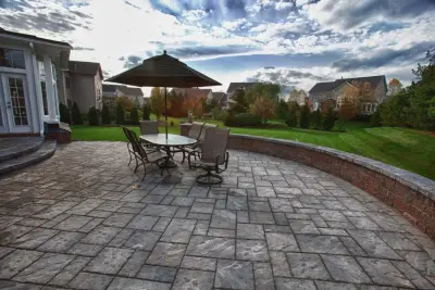 Techo-Bloc Patio featuring Seatwalls and an Outdoor Kitchen by Deckscapes Of VA, LLC