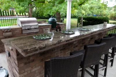 Elegant Outdoor Kitchen, Bar & Dining Space by Quiet Village Landscaping