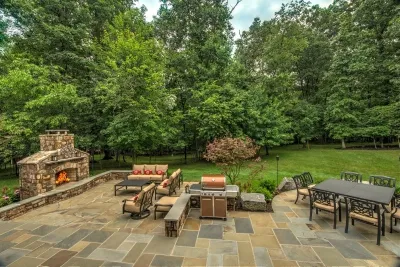 Patio with stone patio & fireplace. by Rock Water Farm