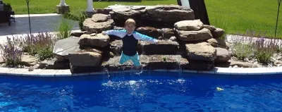 Pool with waterfall by Rock Water Farm