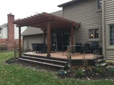 Deck at ground level featuring full-length steps and an elegant pergola — Deck Building & Repair project by DeckThisOut