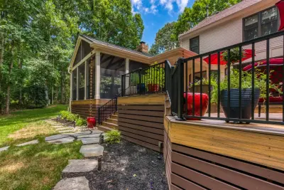 A COZY, WOODEN DECK CRAFTED FOR SOCIAL GATHERINGS by Deckscapes Of VA, LLC