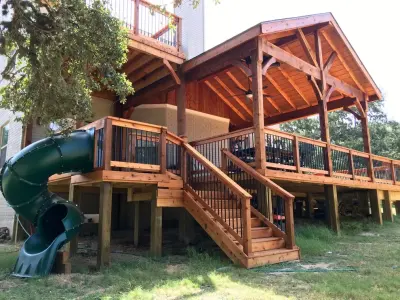 Bespoke Cedar Deck with Roof Extension, Balcony, and Slide - San Antonio, TX — Deck Building & Repair project by Diamond Decks