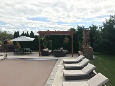 Kansas Patio Project with Pergola, Fireplace, Outdoor Kitchen, and Pool — Deck Building & Repair project by Kansas City Hardscapes