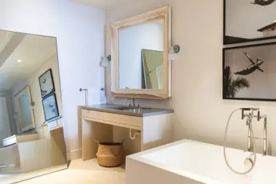 Coastal Condominium Bathroom Featuring Concrete Shower and Vanities — Stone & Concrete Installation project by Thiel Studios