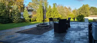 Elevated paver patio featuring stone steps and a fire pit — Stone & Concrete Installation project by Legacy Masonry & Hardscaping