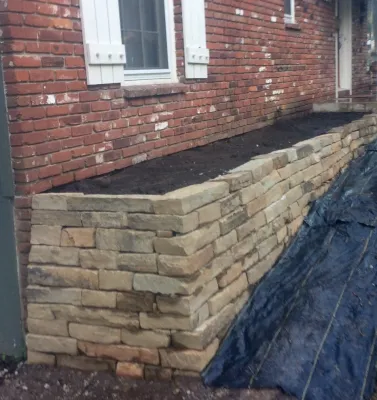 Natural stone retaining wall by Zach's Lawn & Landscaping