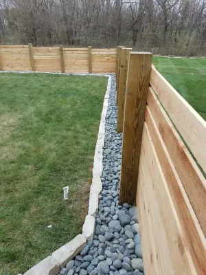 Rock and stone edging around fence — Landscape Construction project by Garden Gate Lawn & Landscape, LLC in Raymore