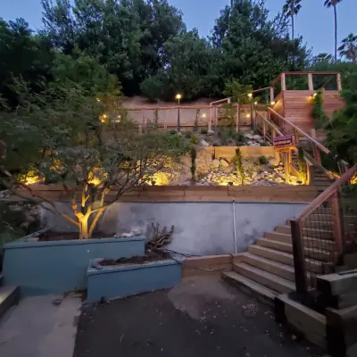 Timber landscape walls and steps with lighting and hog wire fencing — Landscape Construction project by Rease Landscape And Construction